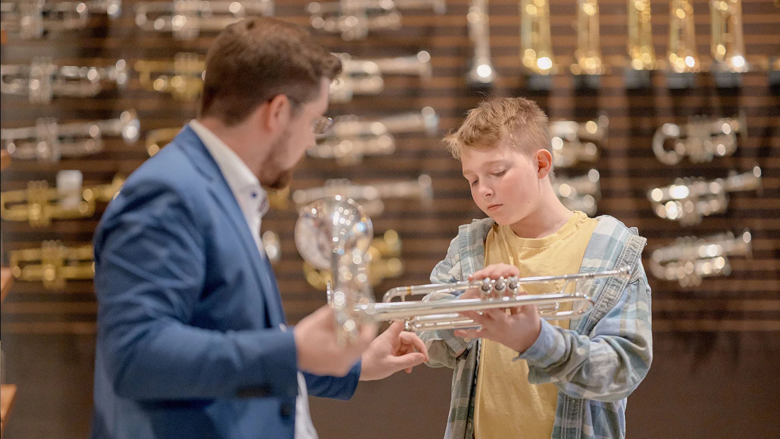 Child choosing a trumpet in a music store
