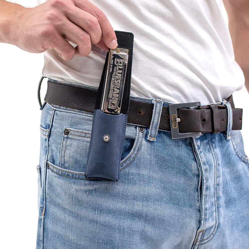 Dark Blue harmonica leather case on belt with harmonica partially pulled out by hand