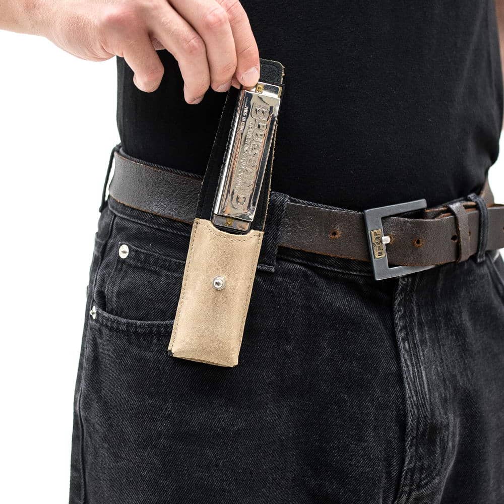 Beige harmonica pouch on belt as harmonica is being pulled out by hand
