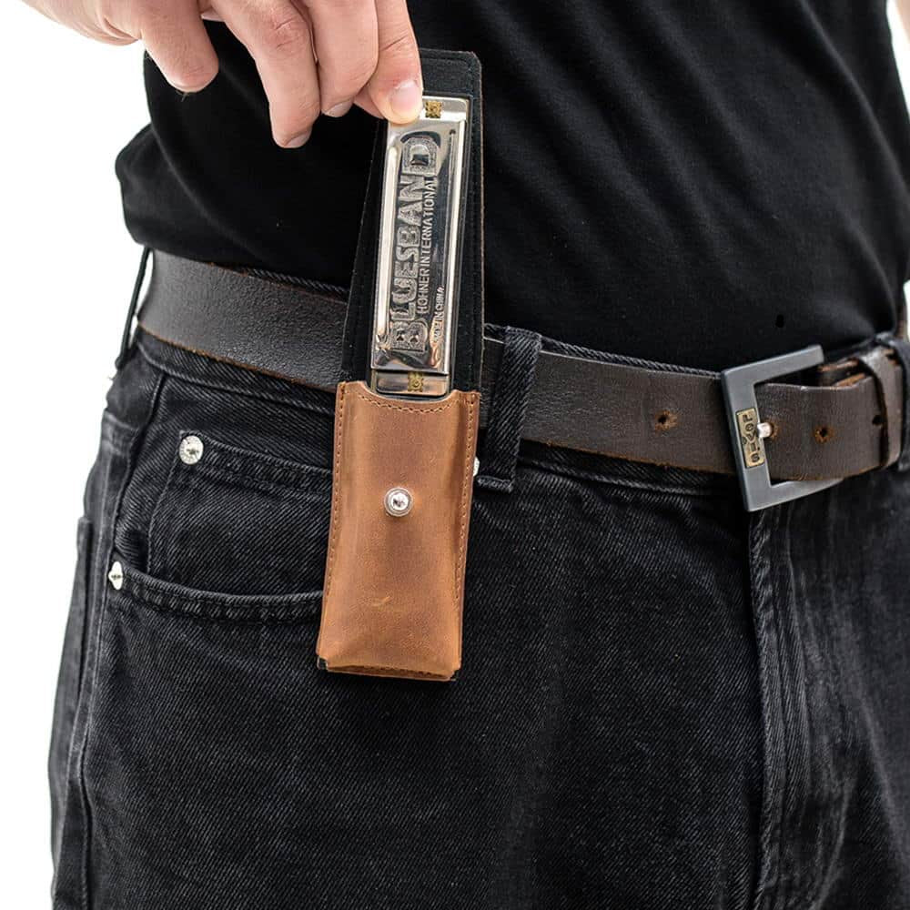 Man removing harmonica from Light brown leather pouch on belt