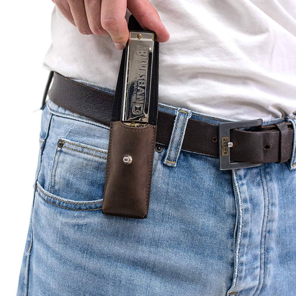 Brown leather harmonica case on belt with harmonica being removed by hand