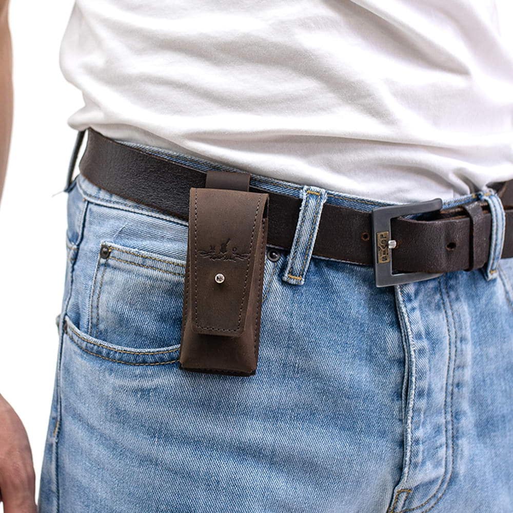Brown leather harmonica holster attached to black leather belt over blue jeans