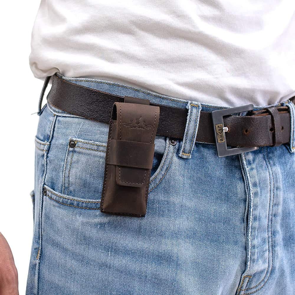 Brown leather harmonica case mounted on black belt with blue jeans outfit.