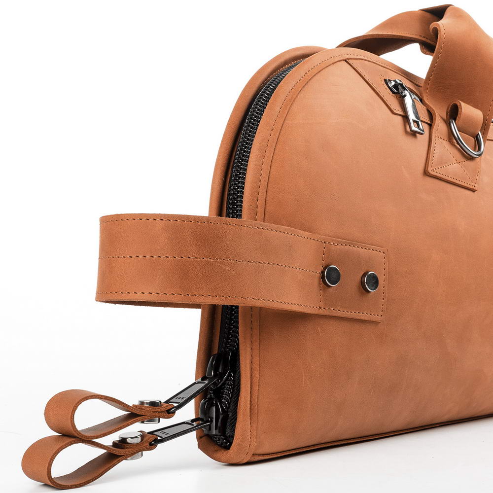 Side view of Trumpet Bag in Crazy Horse Light Brown leather showing reinforced vertical carry handle and two YKK zipper pullers for secure closure