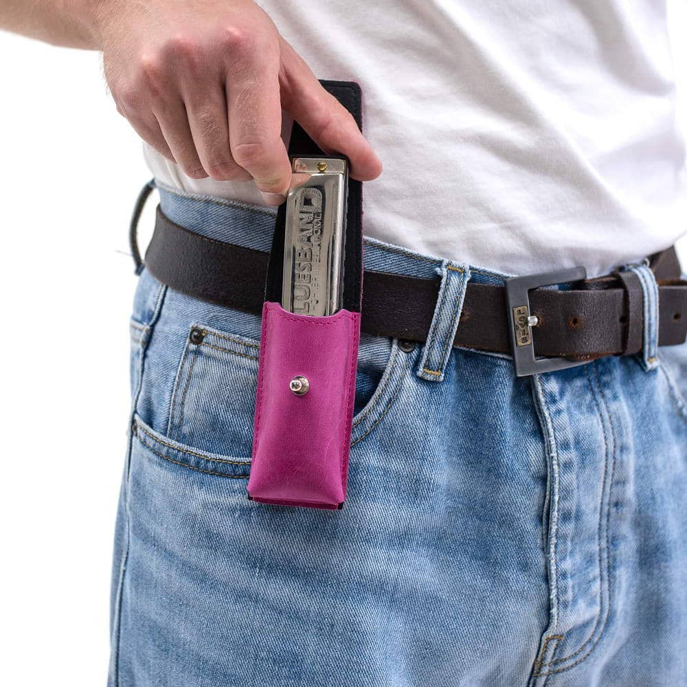 Rose harmonica leather case on belt with harmonica partially pulled out by hand