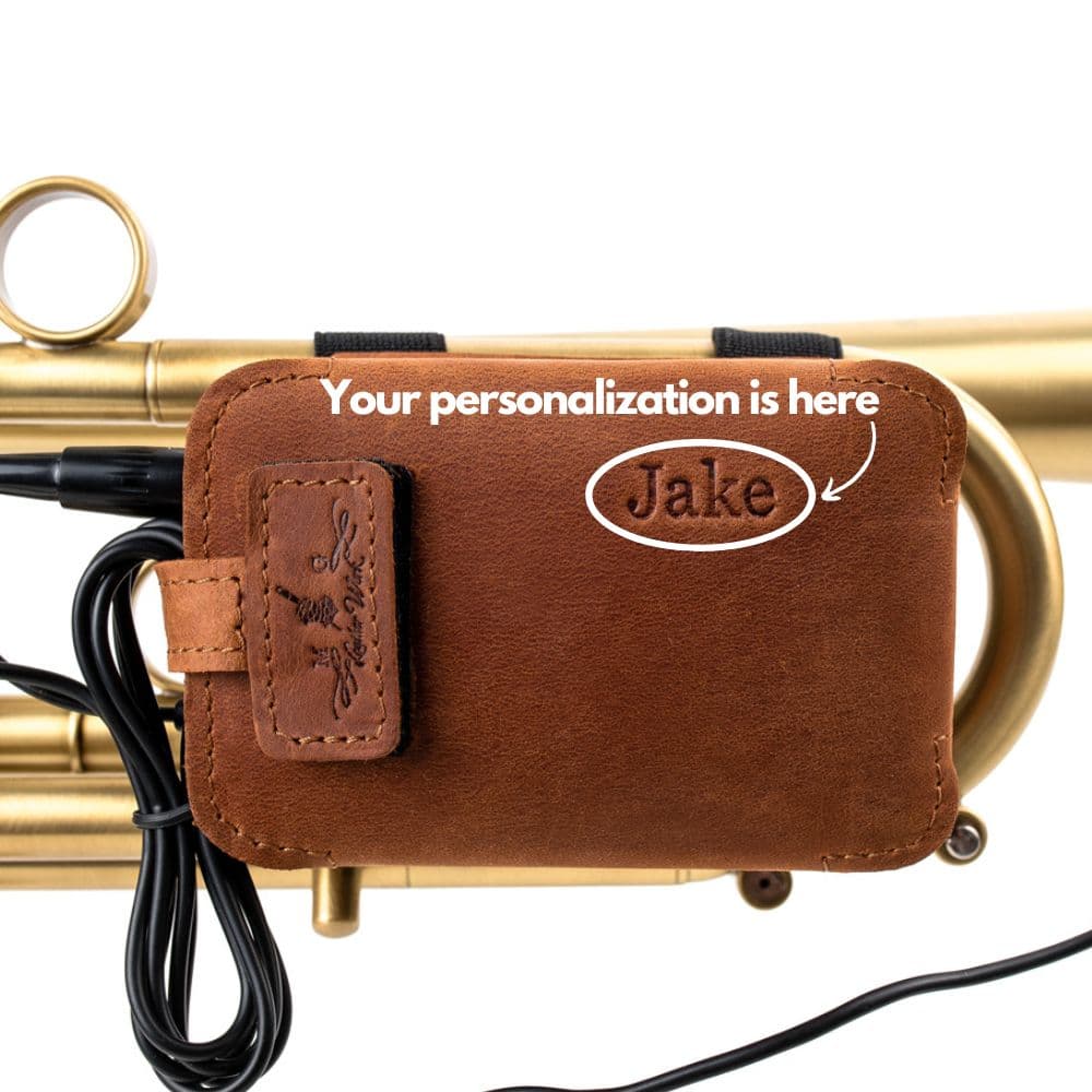 Leather microphone pouch with “Jake” engraving mounted on a trumpet.