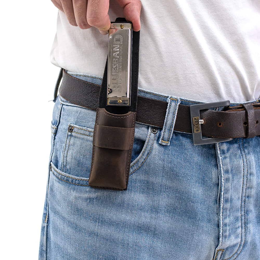 Brown harmonica leather pouch on belt as harmonica is being taken out by hand.