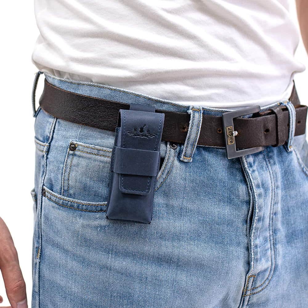 Dark blue harmonica leather case fixed on belt over denim pants.