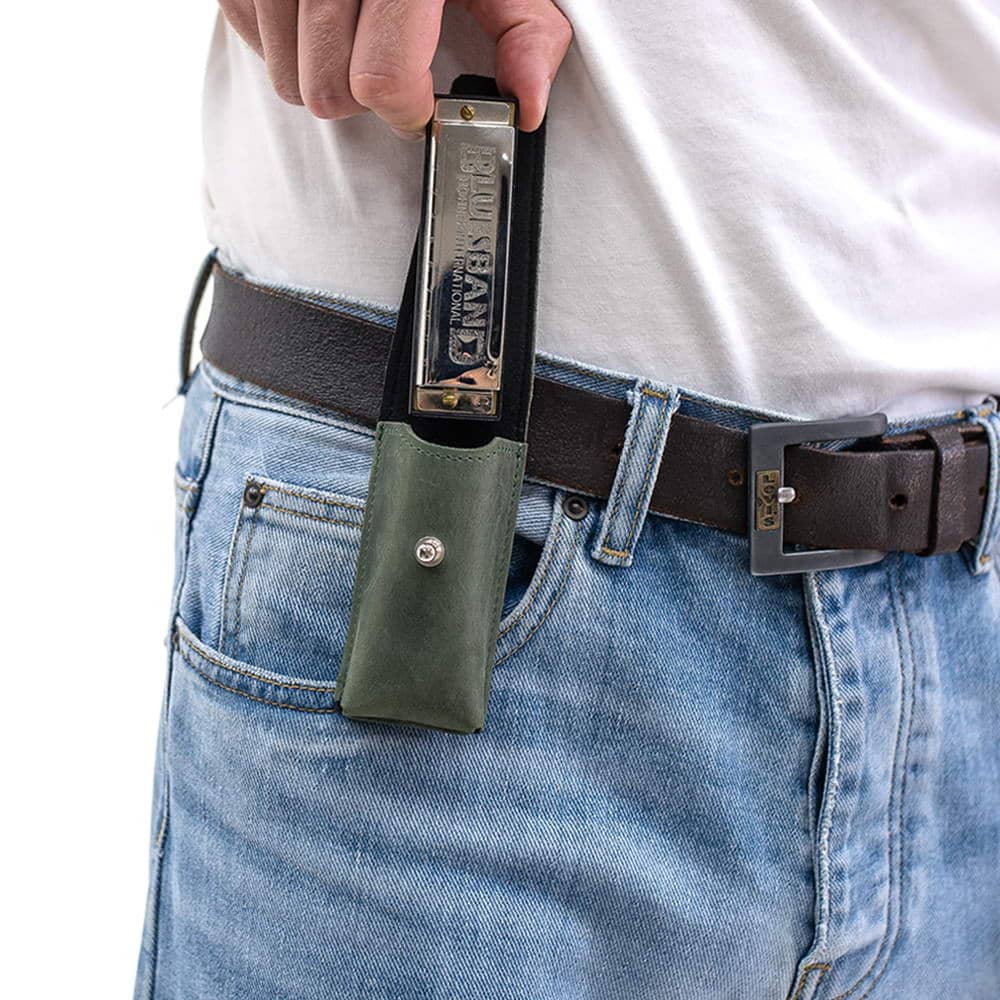 Green harmonica leather holder on belt with harmonica being pulled out.
