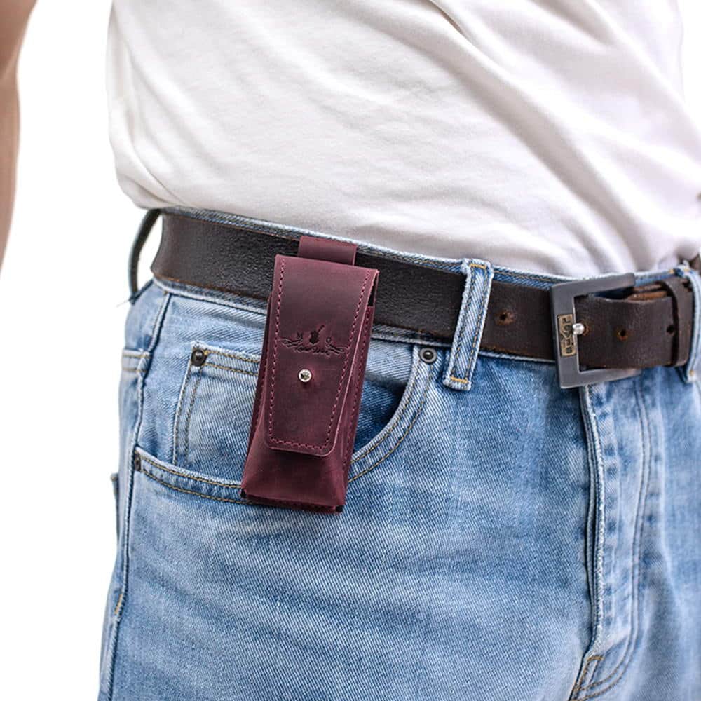 Marsala leather harmonica holster attached to black leather belt over jeans.