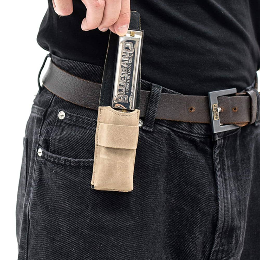 Olive harmonica leather pouch on belt as harmonica is being removed by hand.