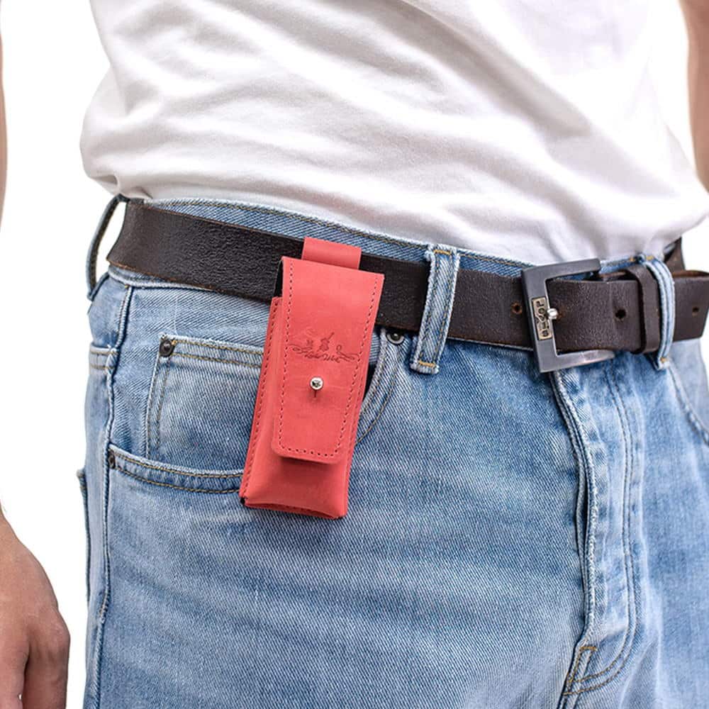 Red leather harmonica holster attached to black belt over blue jeans