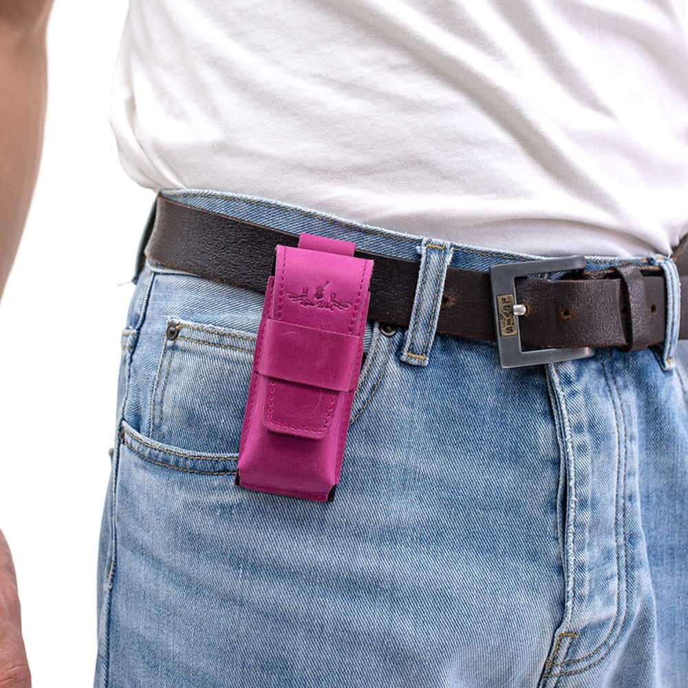 Rose leather harmonica case attached to black belt with jeans.