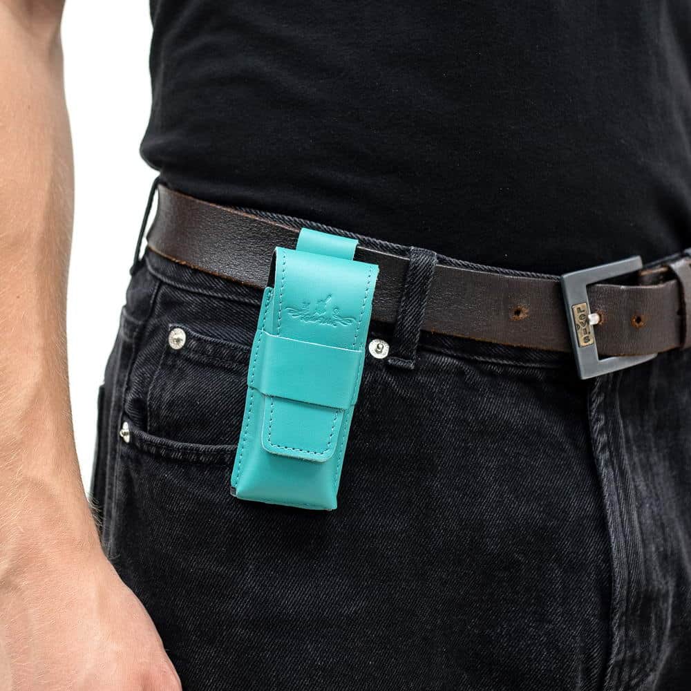 Tiffany leather harmonica case mounted on black belt over denim.