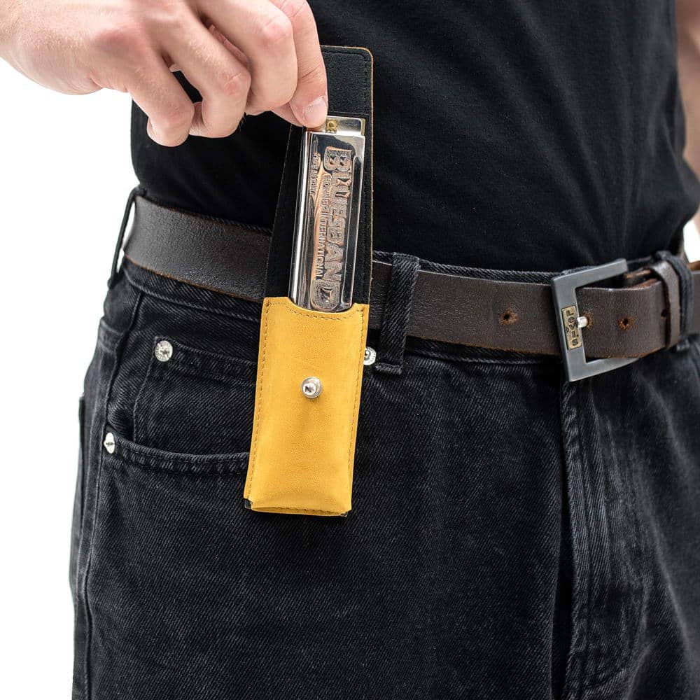 Yellow harmonica holster on belt with harmonica being taken out.