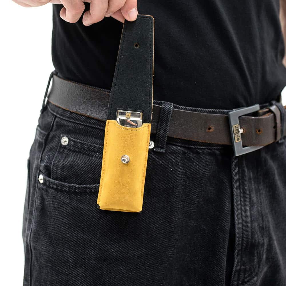 Yellow leather harmonica case on belt clip with flap open showing instrument.